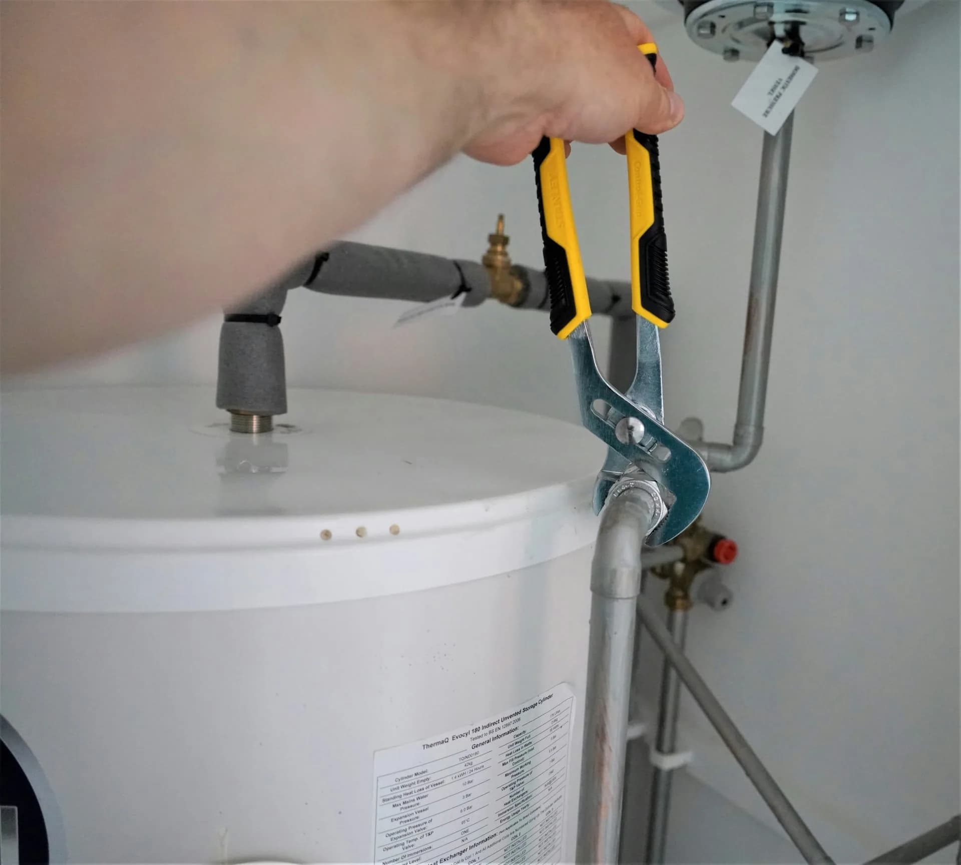 Técnico reparando la conexión de un termo eléctrico afectado por la cal