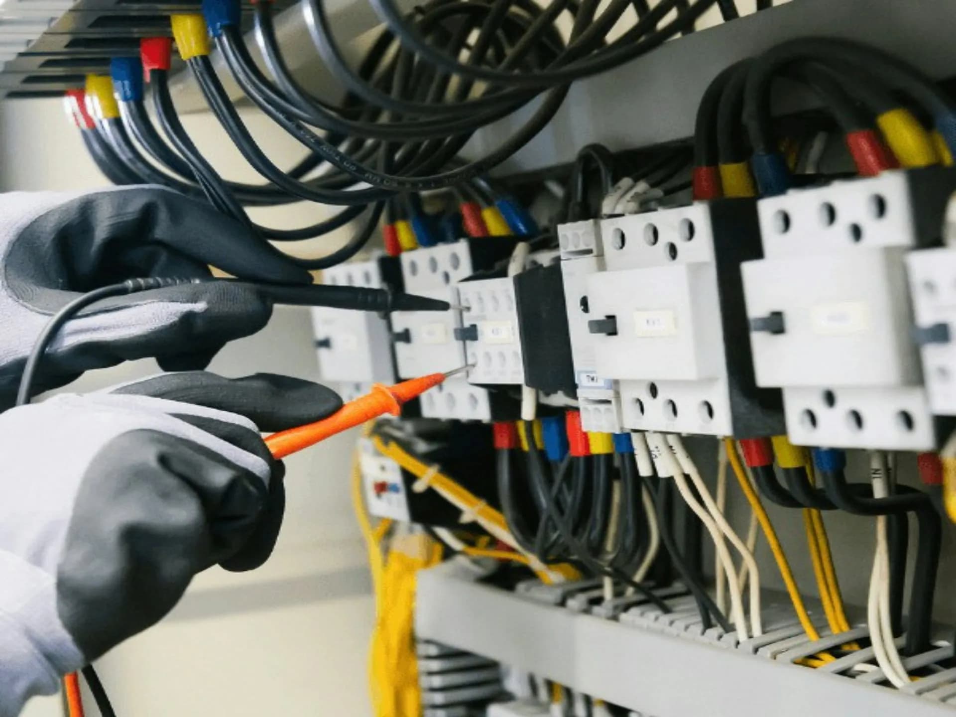 Electricista midiendo con un comprobador en un cuadro eléctrico para localizar una avería