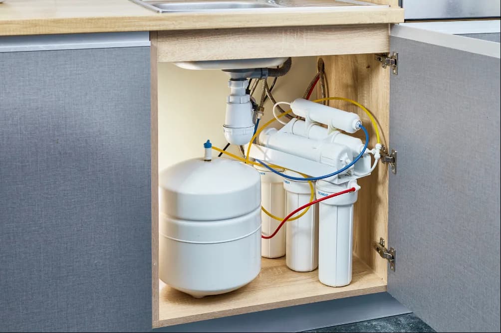 Equipo de ósmosis inversa instalado bajo el fregadero de una cocina