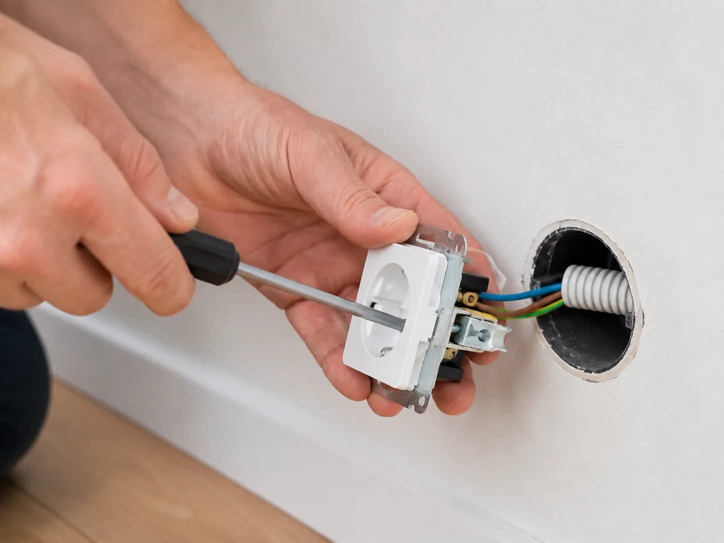 Técnico electricista instalando un mecanismo eléctrico en una pared
