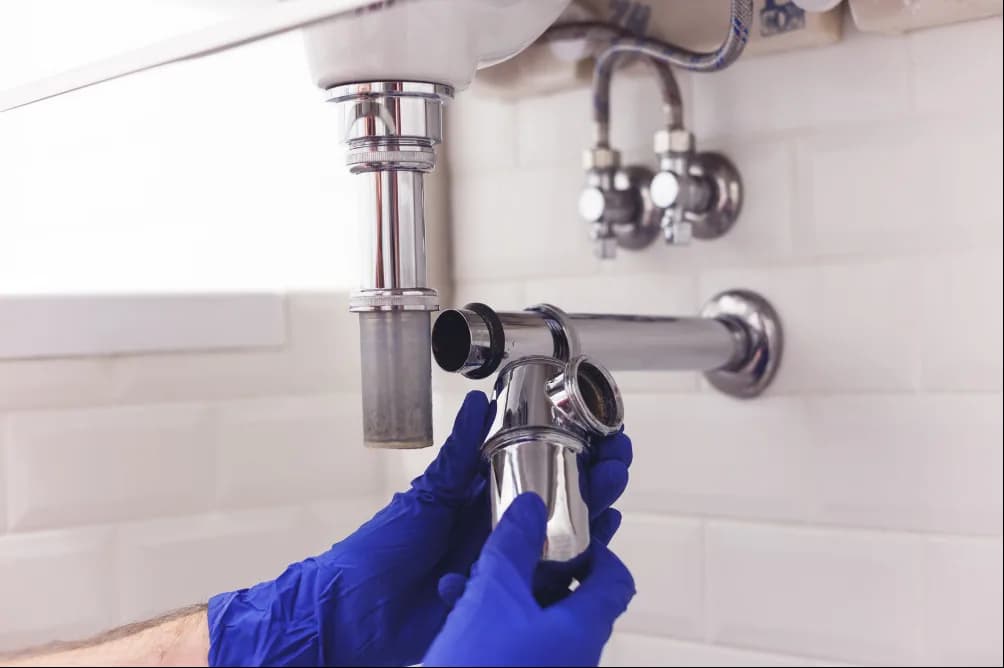 Fontanero desmontando el sifón de un lavabo durante un desatasco
